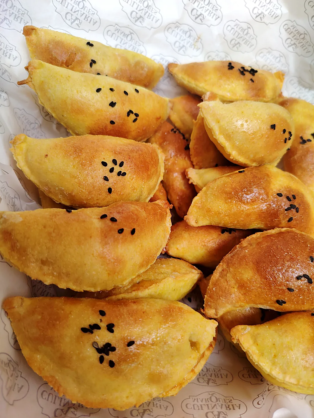 Empanaditas de pollo doradas con ajonjolí negro