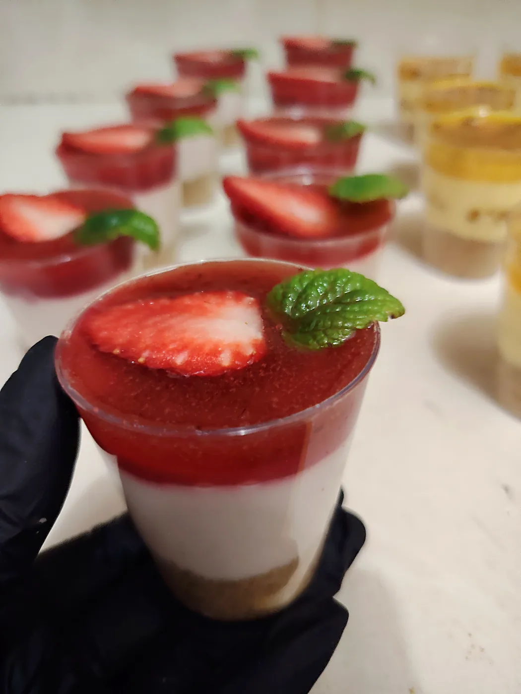 Cheesecake de fresa en vasito con hojita de menta